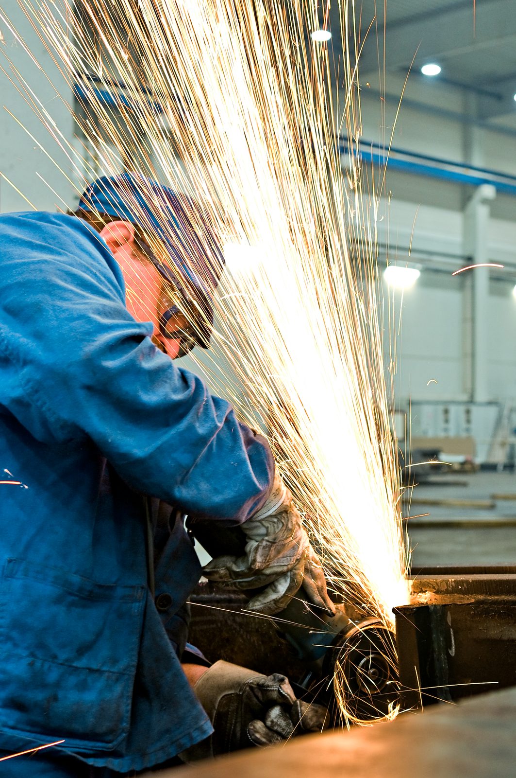 Industriemechaniker und Schlosser im Metallbau beim Entgraten und Schleifen von Stahlblech mit Winkelschleifer – Bock Lorch