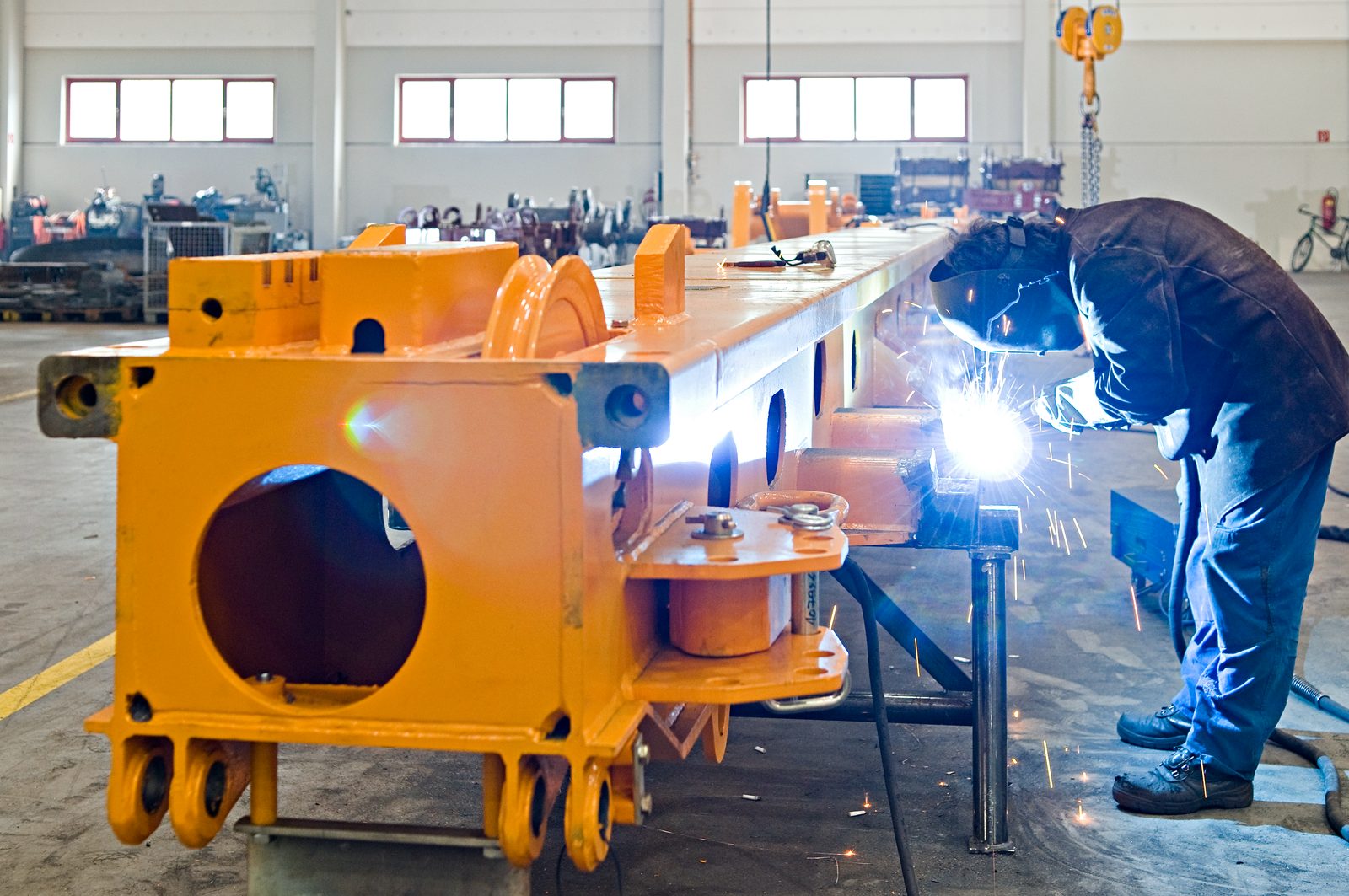 Welder welding a large component for construction machinery – welded assemblies to DIN EN 1090, contract manufacturing at Bock Maschinenbau Lorch